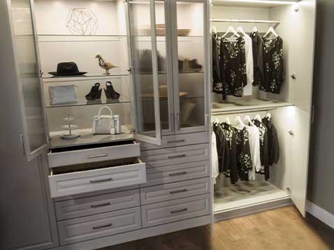 A large, well-organized closet of drawers and hanged clothes